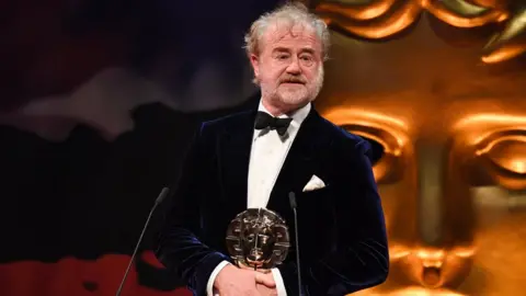 BAFTA Owen Teale on stage holding award