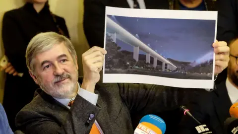 AFP Mayor of Genoa Marco Bucci displays a section plan of the new bridge.