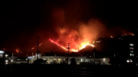 Reuters Flames rise as a wildfire burns on a hill in Kamloops, British Columbia, Canada, 1 July 2021
