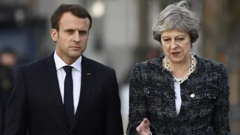 AFP Theresa May speaking to Emmanuel Macron