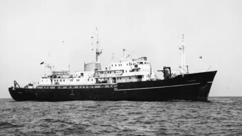 National Oceanography Centre A black and white image of the Discovery sailing in the ocean.