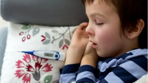 Getty Images Young child sleeping after having temperature taken