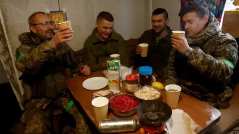 Reuters Ukrainian troops toast each other