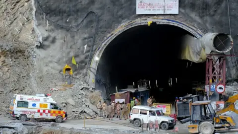 Reuters Ambulances and men waiting outside a tunnel