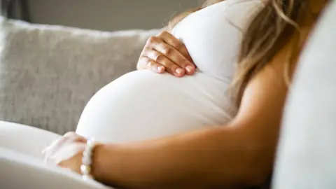 Getty Images Pregnant woman holding her tummy