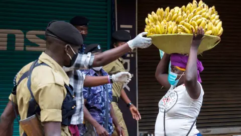 AFP Police officers arrest a banana seller in Kampala, Uganda - Friday 25 June 2021