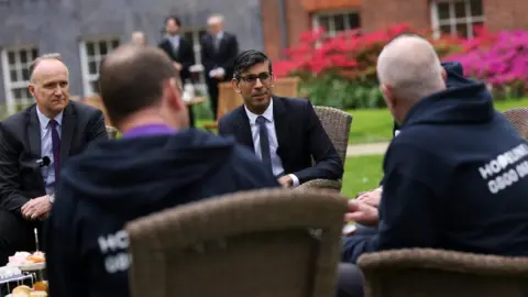 Simon Dawson/No 10 Downing Street Rishi Sunak talking to the 3 Dads in the Downing Street garden