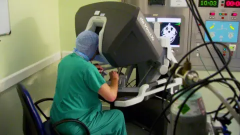 Alan Kirk operates the robot via a console