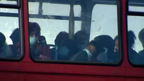 BBC Migrants asleep on board double decker bus at a Kent processing centre