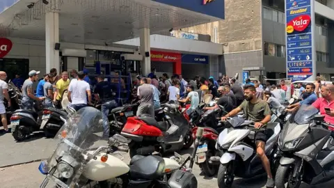 Reuters Motorbike drivers wait to get fuel at a petrol station in Beirut, Lebanon (29 June 2021)