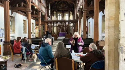 People talking to eachother at the coffee morning in the church