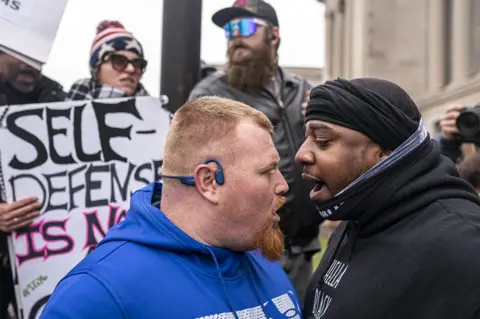 Getty Images Two men argue outside court