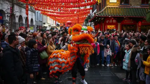 HENRY NICHOLLS/GETTY IMAGES A Chinese Lion Dance team perform for spectators during celebrations for Chinese Lunar New Year of the Dragon in central London on February 10, 2024.