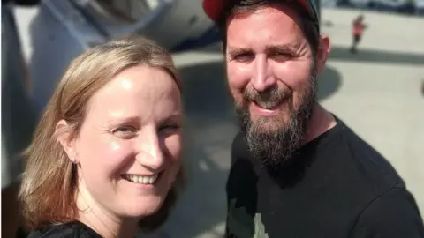 Richard Fletcher/Sarah Wooller The couple waiting to catch a flight