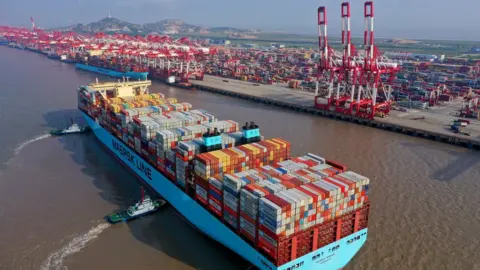 Getty Images Tugboats guide a container ship of Maersk Line at the Yangshan Deepwater Port