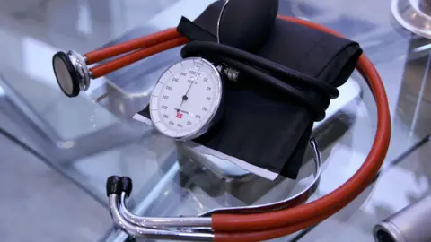 Close up of a medical stethoscope with red tubing and chrome ends