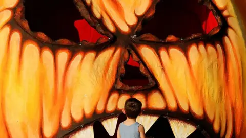 A child looks at a giant Halloween