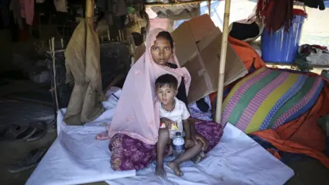 Getty Images Sabikul Nahar poses for a photo with a kid at a refugee camp in Cox's Bazar, Bangladesh on December 19, 2017