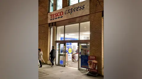 Tesco express entrance with people outside