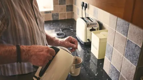 Getty Images Man using electric kettle