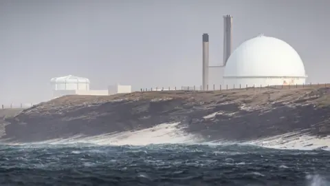Getty Images The Dounreay sphere and adjoining chimneys on a rocky coastline.
