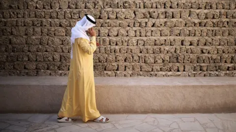 Getty Images A man talks on his mobile phone as he walks through the Dubai Heritage Village on 13 November 2013 in Dubai, United Arab Emirates