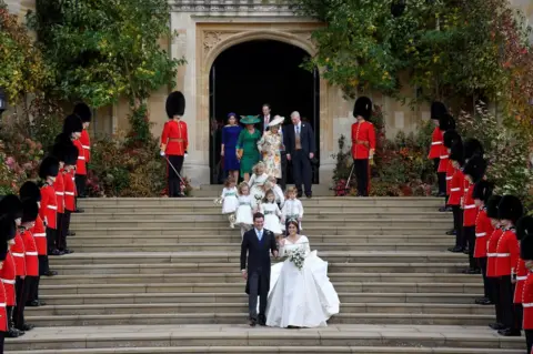 Reuters Princess Eugenie of York and her husband Jack Brooksbank walk down the West Steps of St Georg's Chapel