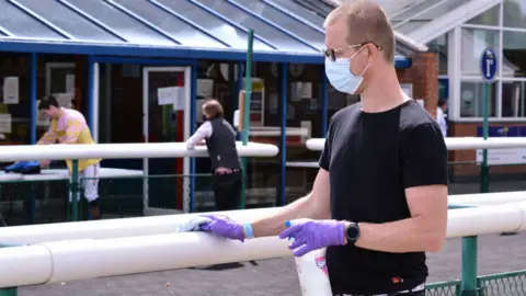 PA Media Staff wiping down surfaces at Leicester Racecourse