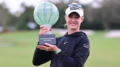 Nelly Korda posing with the Drive on Championship trophy