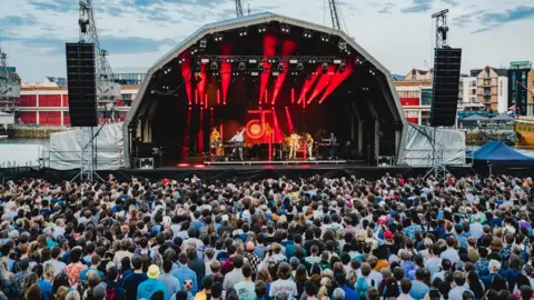 Ania Shrimpton Crowd packed in front of the Bristol Sounds stage with harbour cranes in the background