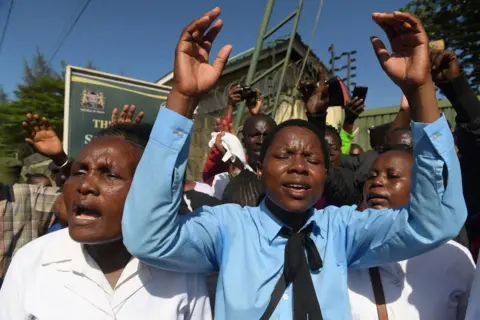 SIMON MAINA/AFP Members of the New Life Prayer Centre and Church sing and pray at the Shanzu law courts, Mombasa, Kenya