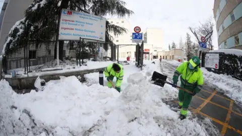 EPA Municipal workers clear snow at entrance to Gregorio Maranon Hospital in Madrid on 10 January 2021