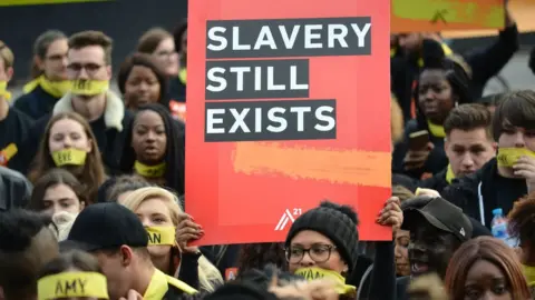 Getty Images protest sign reading slavery still exists