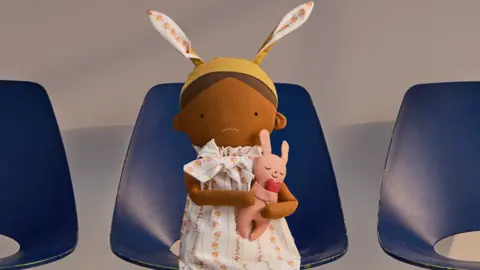 NHS A doll with a sad face holding a sick heart