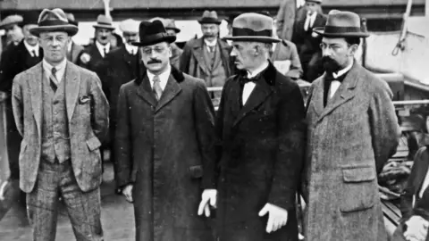 Getty Images/Independent News and Media Robert Barton, Arthur Griffith, Eamon Duggan and Gavan Duffy pictured en route to London during the talks