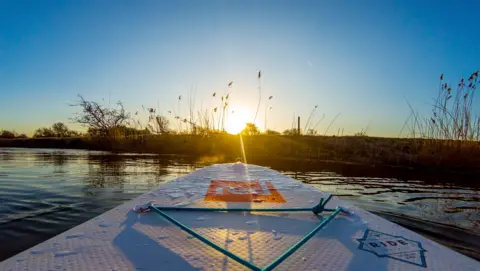 Lucy Bickerton Stand-up paddle boarding at sunrise near Northmoor Lock