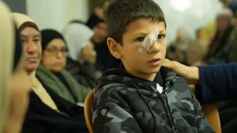 Mustafa Bani Odeh, 8, is comforted by mourners at the home of Najah Bani Odeh in Tammun, in the Israeli-occupied West Bank