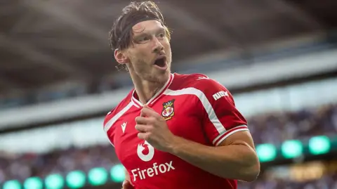 Kieffer Moore runs in celebration after scoring for Wrexham