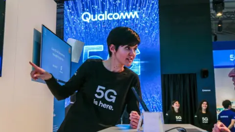 Getty Images An employee talks about 5G at Qualcomm's booth at Mobile World Congress 2019 in Barcelona