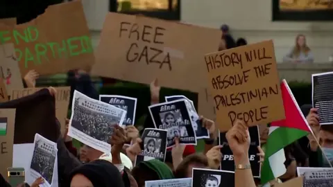 Protestors hold signs supporting Palestine