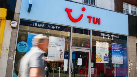 Getty Images man walks past Tui shop