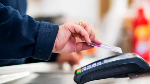 Getty Images Shopper uses contactless