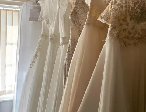 Yulia's dresses on a rail.