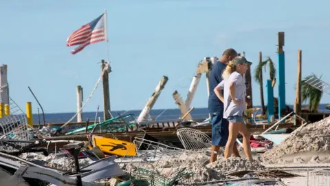 People walk past destruction at Fort Myers Beach, Florida, on Friday 30 September