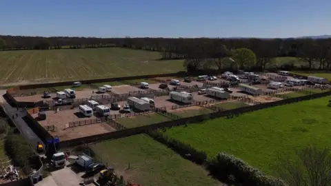 An aerial shot of a plot of land with caravans and static homes on it.