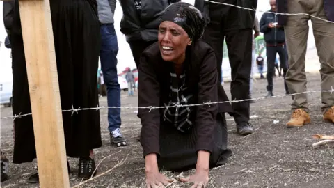 Reuters A family member of the Ethiopian Airlines crash victims mourns at the fenced-off accident site