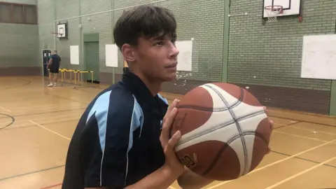 Jonathan Park/BBC Arsenii Handzii playing basketball