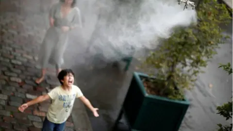 Reuters A child cools off under a water spray as a heatwave rolls over Paris, France, August 8, 2020.