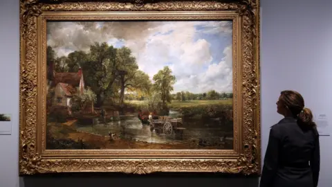 PA A V&A museum employee looking at John Constable's 1821 painting The Hay Wain