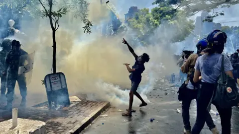 BBC/Tessa Wong A young boy hurling tear gas canister